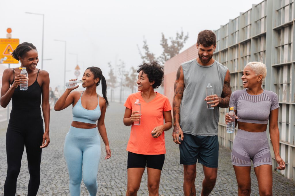 Group of athletes rehydrating after training in the city